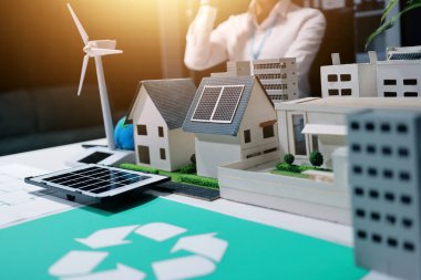 İki iş adamı ekibi güneş pili ve rüzgar türbini jeneratörü ile sürdürülebilir ve yenilenebilir temiz enerji ürünü, CO2 emisyonları küresel ısınma projesini planlıyor ve tartışıyor.