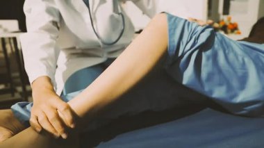 Fizyoterapist bir hasta için diz egzersizi yapıyor.