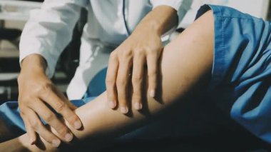 Fizyoterapist bir hasta için diz egzersizi yapıyor.