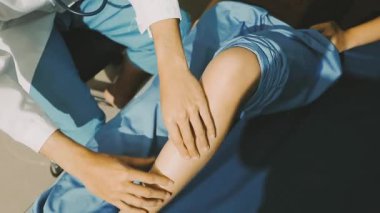 Fizyoterapist bir hasta için diz egzersizi yapıyor.