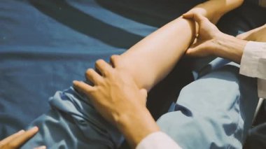 Fizyoterapist bir hasta için diz egzersizi yapıyor.