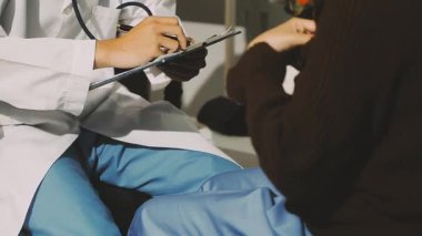 Kadın doktor, kadının elini tutuyor. Rahatlık veriyor, sağlık hizmeti veriyor, tıbbi yardım alıyor, güven desteği veriyor. Sağlık ziyareti sırasında, kısır hastayı rahatlatmaya teşvik ediyor.