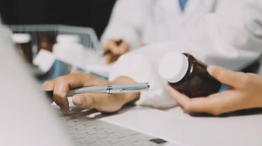Medical team meeting analyzing blood test results in hospital laboratory. Doctors and scientists in lab coats are having a discussion about blood test result, holding test tubes and taking notes.