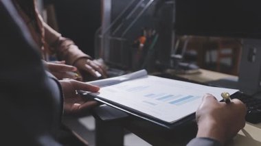 Ofiste çalışan denetçi ve muhasebeci ekibi mali verileri ve muhasebe kayıtlarını hesap makinesiyle analiz ediyor. Muhasebe şirketi kârlı nakit akışı için finansman ve vergilendirme planlaması sağlıyor