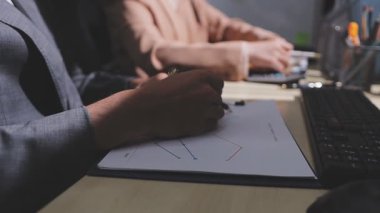 Ofiste çalışan denetçi ve muhasebeci ekibi mali verileri ve muhasebe kayıtlarını hesap makinesiyle analiz ediyor. Muhasebe şirketi kârlı nakit akışı için finansman ve vergilendirme planlaması sağlıyor