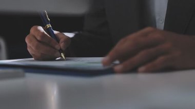 Ofiste çalışan denetçi ve muhasebeci ekibi mali verileri ve muhasebe kayıtlarını hesap makinesiyle analiz ediyor. Muhasebe şirketi kârlı nakit akışı için finansman ve vergilendirme planlaması sağlıyor