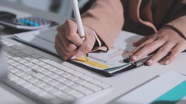 Ofiste çalışan denetçi ve muhasebeci ekibi mali verileri ve muhasebe kayıtlarını hesap makinesiyle analiz ediyor. Muhasebe şirketi kârlı nakit akışı için finansman ve vergilendirme planlaması sağlıyor