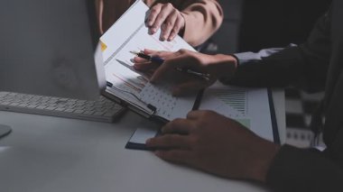 Ofiste çalışan denetçi ve muhasebeci ekibi mali verileri ve muhasebe kayıtlarını hesap makinesiyle analiz ediyor. Muhasebe şirketi kârlı nakit akışı için finansman ve vergilendirme planlaması sağlıyor