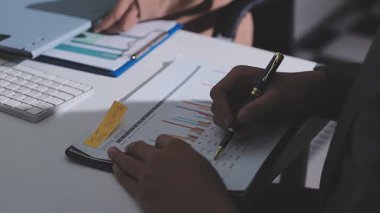 Ofiste çalışan denetçi ve muhasebeci ekibi mali verileri ve muhasebe kayıtlarını hesap makinesiyle analiz ediyor. Muhasebe şirketi kârlı nakit akışı için finansman ve vergilendirme planlaması sağlıyor