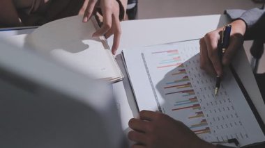 Ofiste çalışan denetçi ve muhasebeci ekibi mali verileri ve muhasebe kayıtlarını hesap makinesiyle analiz ediyor. Muhasebe şirketi kârlı nakit akışı için finansman ve vergilendirme planlaması sağlıyor