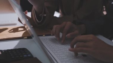 Ofiste çalışan denetçi ve muhasebeci ekibi mali verileri ve muhasebe kayıtlarını hesap makinesiyle analiz ediyor. Muhasebe şirketi kârlı nakit akışı için finansman ve vergilendirme planlaması sağlıyor