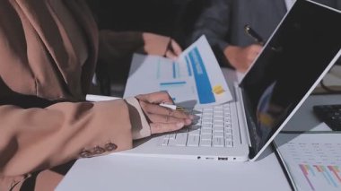 Ofiste çalışan denetçi ve muhasebeci ekibi mali verileri ve muhasebe kayıtlarını hesap makinesiyle analiz ediyor. Muhasebe şirketi kârlı nakit akışı için finansman ve vergilendirme planlaması sağlıyor