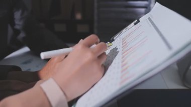 Ofiste çalışan denetçi ve muhasebeci ekibi mali verileri ve muhasebe kayıtlarını hesap makinesiyle analiz ediyor. Muhasebe şirketi kârlı nakit akışı için finansman ve vergilendirme planlaması sağlıyor