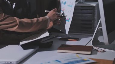 Ofiste çalışan denetçi ve muhasebeci ekibi mali verileri ve muhasebe kayıtlarını hesap makinesiyle analiz ediyor. Muhasebe şirketi kârlı nakit akışı için finansman ve vergilendirme planlaması sağlıyor