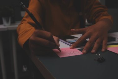 Uxui tasarımcılarından oluşan bir ekip bilgisayar ekranını işaret ederek ofiste yeni mobil uygulama tasarımını tartışıyor.