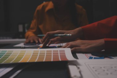 Uxui tasarımcılarından oluşan bir ekip bilgisayar ekranını işaret ederek ofiste yeni mobil uygulama tasarımını tartışıyor.