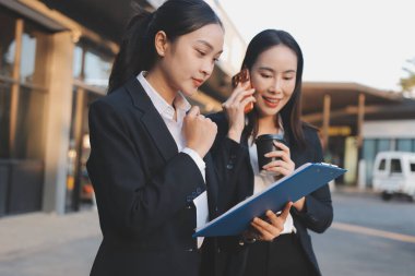 İş adamları modern ofisin önünde yürür ve birbirleriyle konuşurlar.