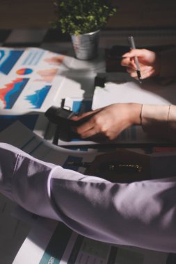 Above table with finance papers, graphs and big data during teamwork meeting with accounting or marketing team discussing budget, strategy or growth development. Closeup of SEO team doing research