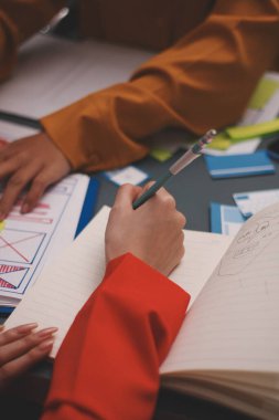 Uxui tasarımcılarından oluşan bir ekip bilgisayar ekranını işaret ederek ofiste yeni mobil uygulama tasarımını tartışıyor.