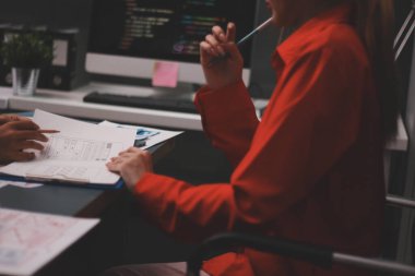 Uxui tasarımcılarından oluşan bir ekip bilgisayar ekranını işaret ederek ofiste yeni mobil uygulama tasarımını tartışıyor.