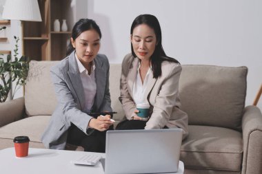 İki iş kadını ofiste verimli bir toplantı yapıyorlarmış. İş konularını tartışıyorlar, sözleşme imzalıyorlar ve el sıkışıyorlar.