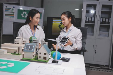 İki iş adamı ekibi güneş pili ve rüzgar türbini jeneratörü ile sürdürülebilir ve yenilenebilir temiz enerji ürünü, CO2 emisyonları küresel ısınma projesini planlıyor ve tartışıyor.