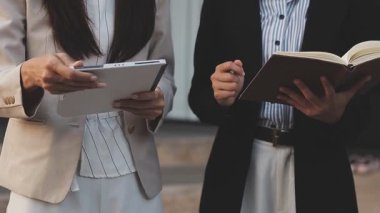 Yakınlarda grafikleri ve dizüstü bilgisayarı olan bir hesap makinesinde finansal veri hesaplayan bir kişi