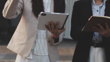 Yakınlarda grafikleri ve dizüstü bilgisayarı olan bir hesap makinesinde finansal veri hesaplayan bir kişi