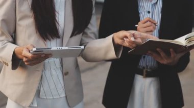 Yakınlarda grafikleri ve dizüstü bilgisayarı olan bir hesap makinesinde finansal veri hesaplayan bir kişi