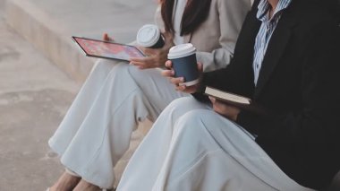 İş adamları modern ofisin önünde yürür ve birbirleriyle konuşurlar.