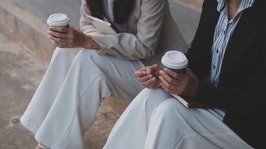 İş adamları modern ofisin önünde yürür ve birbirleriyle konuşurlar.