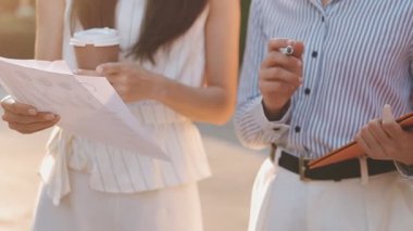 İş adamları modern ofisin önünde yürür ve birbirleriyle konuşurlar.