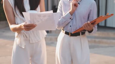 İş adamları modern ofisin önünde yürür ve birbirleriyle konuşurlar.