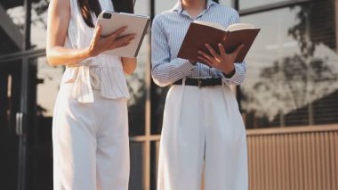 İş adamları modern ofisin önünde yürür ve birbirleriyle konuşurlar.