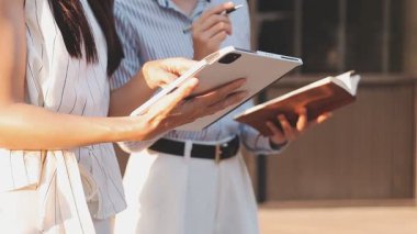 İş adamları modern ofisin önünde yürür ve birbirleriyle konuşurlar.