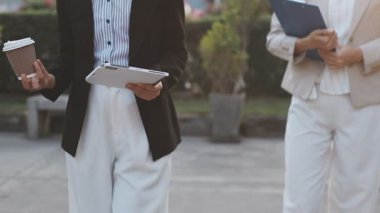 İş adamları modern ofisin önünde yürür ve birbirleriyle konuşurlar.