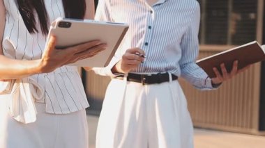 İş adamları modern ofisin önünde yürür ve birbirleriyle konuşurlar.