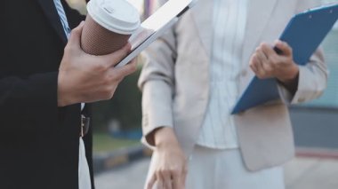 İş adamları modern ofisin önünde yürür ve birbirleriyle konuşurlar.