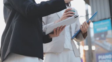 İş adamları modern ofisin önünde yürür ve birbirleriyle konuşurlar.