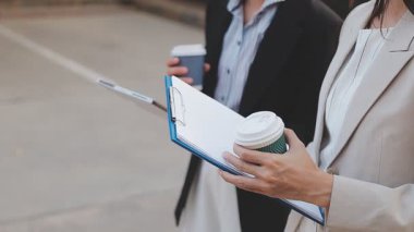 İş adamları modern ofisin önünde yürür ve birbirleriyle konuşurlar.