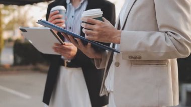 İş adamları modern ofisin önünde yürür ve birbirleriyle konuşurlar.