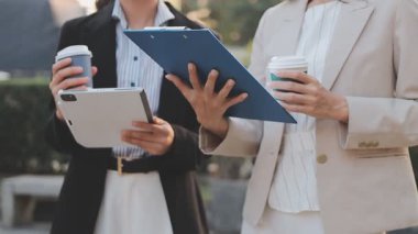 İş adamları modern ofisin önünde yürür ve birbirleriyle konuşurlar.