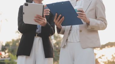 İş adamları modern ofisin önünde yürür ve birbirleriyle konuşurlar.