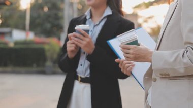 İş adamları modern ofisin önünde yürür ve birbirleriyle konuşurlar.