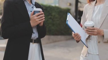 İş adamları modern ofisin önünde yürür ve birbirleriyle konuşurlar.