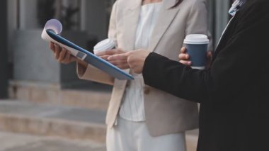 İş adamları modern ofisin önünde yürür ve birbirleriyle konuşurlar.