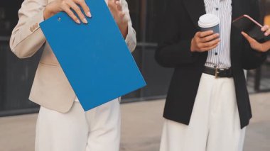 İş adamları modern ofisin önünde yürür ve birbirleriyle konuşurlar.