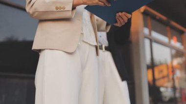 İş adamları modern ofisin önünde yürür ve birbirleriyle konuşurlar.