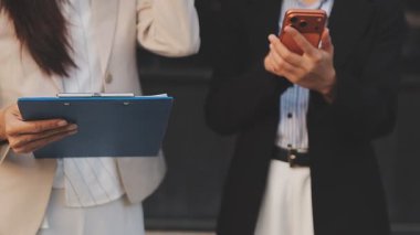 İş adamları modern ofisin önünde yürür ve birbirleriyle konuşurlar.