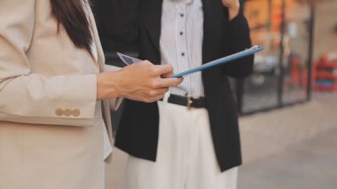 İş adamları modern ofisin önünde yürür ve birbirleriyle konuşurlar.